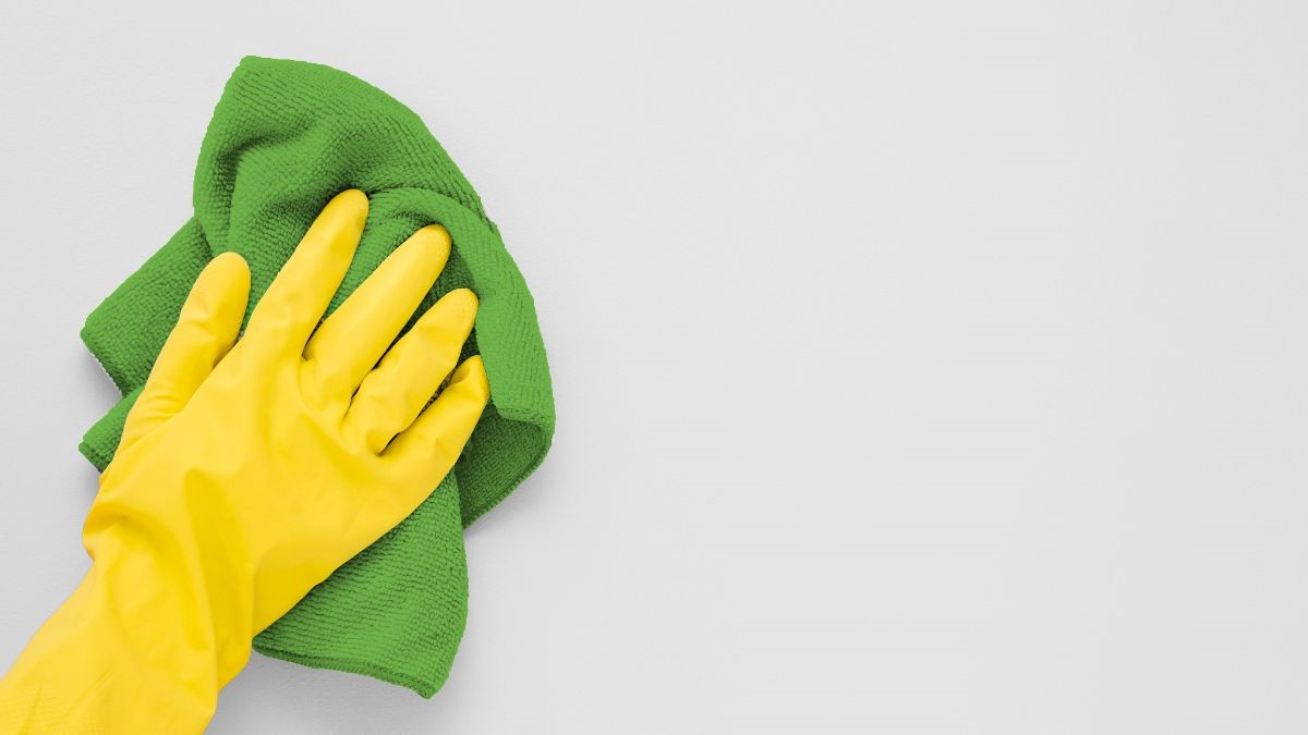 Hand in rubber glove cleaning with green cloth, Floorbrite